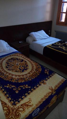 dos camas sentadas una al lado de la otra en una habitación en Hôtel chahrazad en Imouzzer du Kandar