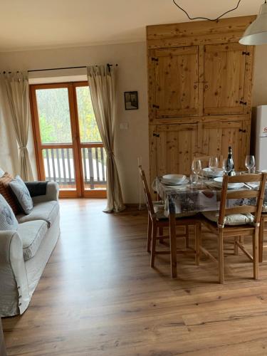 a living room with a table and a couch at San Marco FARMHOUSE with a view. in Sauze dʼOulx