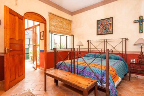a bedroom with a bed and a wooden bench at Beautiful 1 Bedroom apt @ San Miguel Allende (R1) in San Miguel de Allende