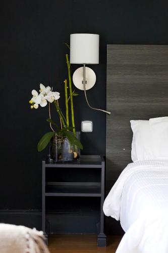 a black bedroom with a table with a lamp and flowers at Hotel Rio Bidasoa in Hondarribia