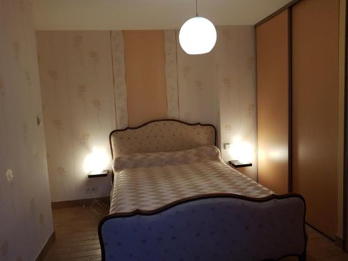 a bedroom with a bed and two lights on the wall at Gîte en Baie du Mont Saint Michel in Cherrueix