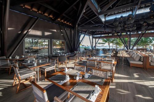 un restaurante con mesas y sillas de madera en Unique Club at Lopesan Costa Bávaro Resort, en Punta Cana