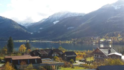 a view of a lake with houses and mountains at Haus Birke in Weissensee