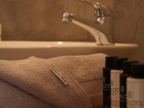 a bathroom with a towel and a sink and a tub at Galini Rooms & Apartments in Finikas