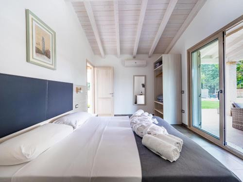 een slaapkamer met een groot wit bed en een groot raam bij Sa Costa in La Caletta