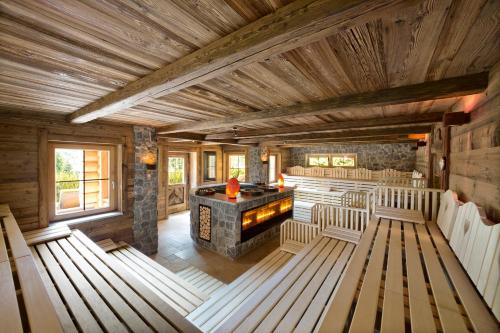 a large room with a stone fireplace in a cabin at Wellnessresidenz Alpenrose in Maurach