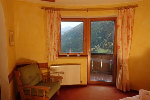 a living room with a chair and a large window at Apart Stotter in Kappl