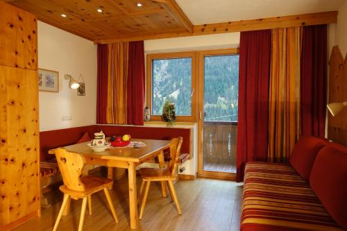 a living room with a table and a couch and a window at Apart Stotter in Kappl