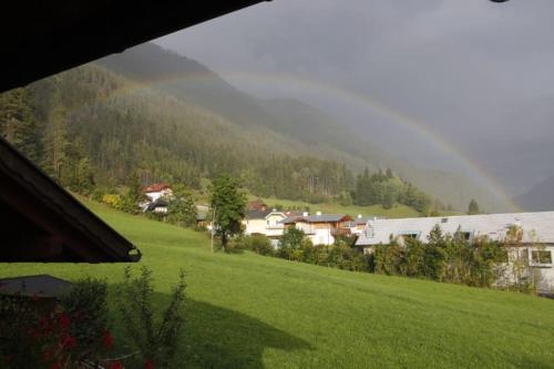 a view of a green field with houses and a mountain at Haus Birke in Weissensee