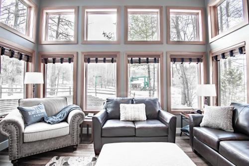 a living room with two couches and windows at 652 Disciples Village in Boyne Falls