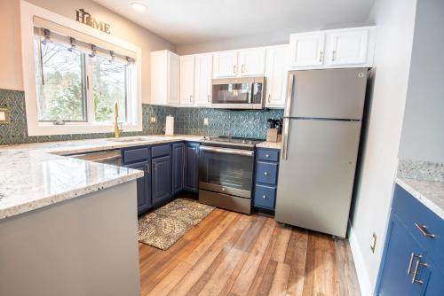 a kitchen with blue cabinets and a white refrigerator at 652 Disciples Village in Boyne Falls