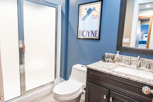 a bathroom with a toilet and a sink and a mirror at 652 Disciples Village in Boyne Falls