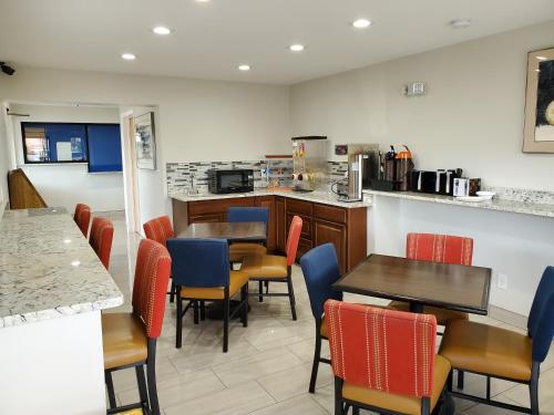 a restaurant with tables and chairs and a kitchen at Travelodge by Wyndham Albuquerque West in Albuquerque