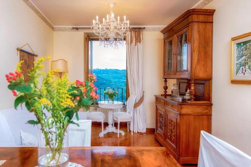 ein Esszimmer mit einem Tisch und einer Vase aus Blumen in der Unterkunft Ripa Medici, camere con vista e parcheggio incluso in Orvieto