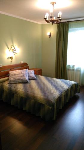 a bed in a bedroom with a large window at Гостевой таунхаус in Demidov