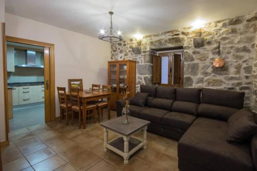 una sala de estar con un sofá y una mesa en Alojamiento Rural URGAIN I y II, en Lekunberri
