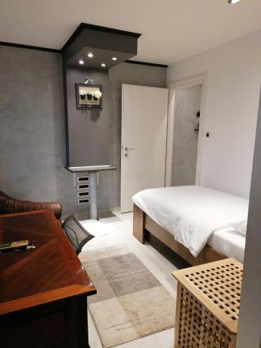 a bedroom with a bed and a table and a desk at Via Corso in Rijeka