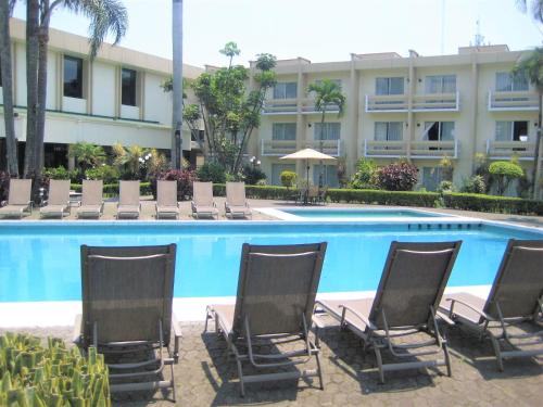 a group of chairs sitting in front of a pool at Hotel Villa Florida Córdoba in Córdoba