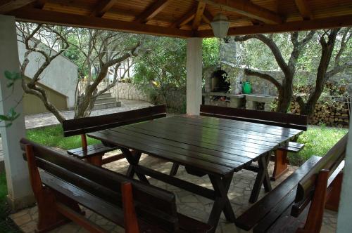 a wooden table and benches on a patio at Apartments Jurina in Krk