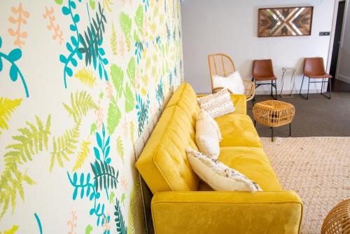 a yellow couch in a living room with a wall at The EO Inn - Downtown Orlando in Orlando