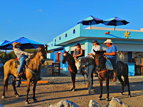 a group of people riding horses in front of a building at Villa Star of the Sea in Barra de Navidad