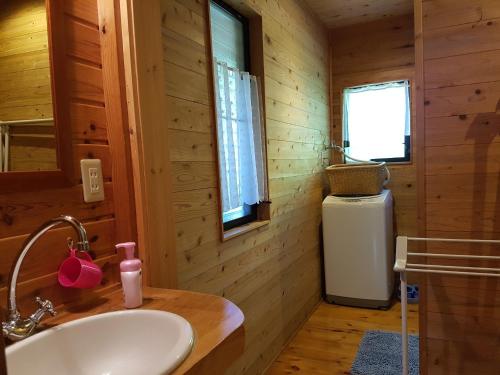 a bathroom with a white sink in a wooden cabin at Ryoshuku Lassi / Vacation STAY 47925 in Koga