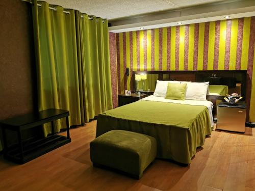 um quarto com uma cama, uma mesa e cortinas verdes em Fantasy Suites em Lima