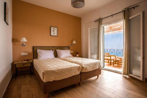 a bedroom with a bed with a view of the ocean at Yaliskari Beach in Pelekas
