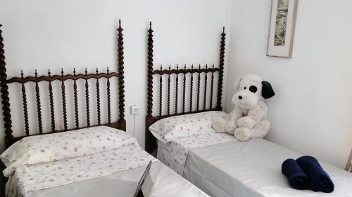 a stuffed dog sitting on two beds in a room at Ca La Roseta in Castellfollit de la Roca