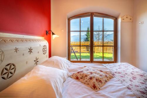 a bed in a room with a window at Butorowy Dwór in Kościelisko