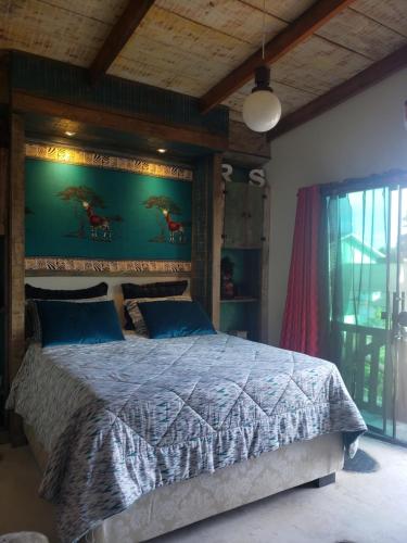 a bedroom with a large bed with blue pillows at Recanto Rustico Itapoá in Itapoa