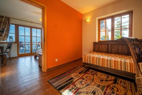 a bedroom with orange walls and a bed with a rug at Butorowy Dwór in Kościelisko