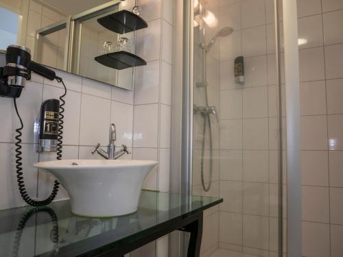 a bathroom with a sink and a shower at Hotel Hague Center in The Hague