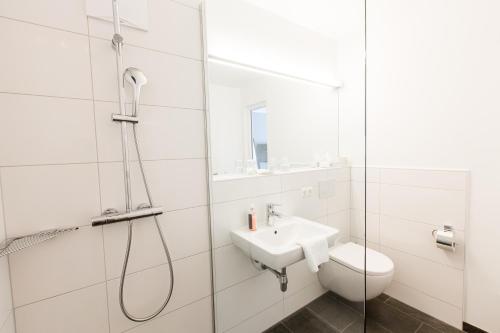 a bathroom with a shower and a toilet and a sink at Wallner - Hotel & Wirt in Arnoldstein
