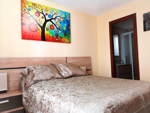 een slaapkamer met een bed en een schilderij aan de muur bij Apartamentos Ruz in Córdoba