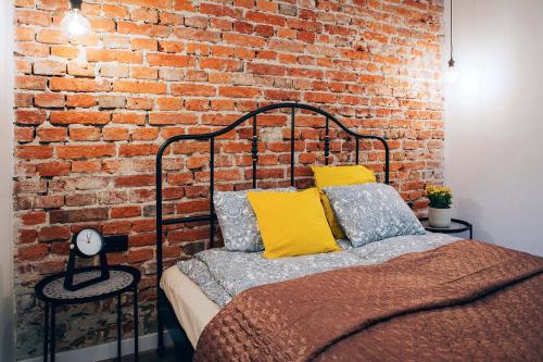 a bedroom with a brick wall and a bed at Cosy Apartment in Kraków