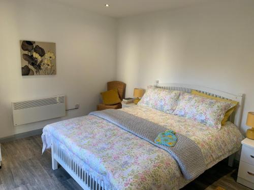 ein Schlafzimmer mit einem Bett mit einer farbenfrohen Tagesdecke in der Unterkunft The Garden room in Derry Londonderry