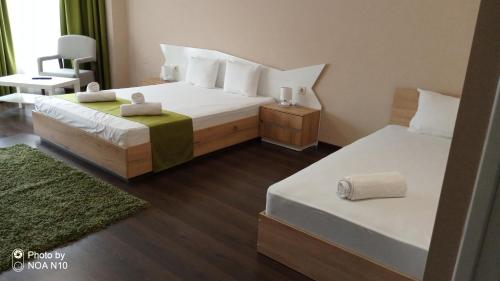 a hotel room with two beds and a chair at Hotel Oppium Restaurant & Garden in Ruse