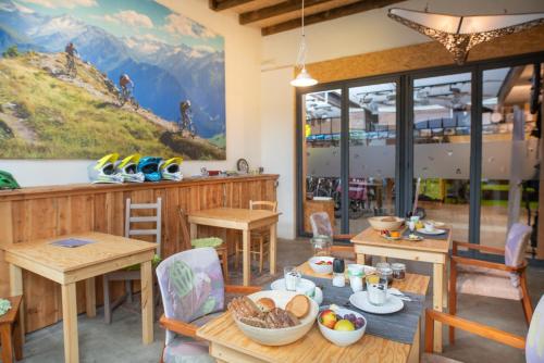 een eetkamer met tafels en stoelen en een muurschildering van de bergen bij sport B&B De Veluwezoom in Velp