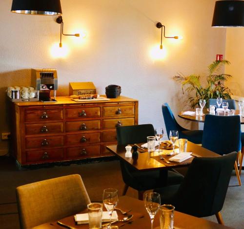a restaurant with tables and chairs and a dresser at Sure Hotel by Best Western Châteauroux in Le Poinçonnet