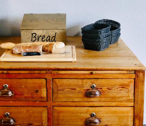 a wooden dresser with a plate of bread on it at Sure Hotel by Best Western Châteauroux in Le Poinçonnet