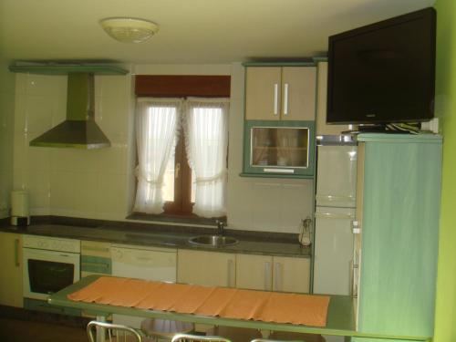 a kitchen with a refrigerator and a counter top at Apartamentos Rurales Los Solares in Mogro