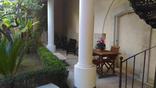 a porch with columns and a table and chairs at Palazzo Rossi suite in Canosa di Puglia