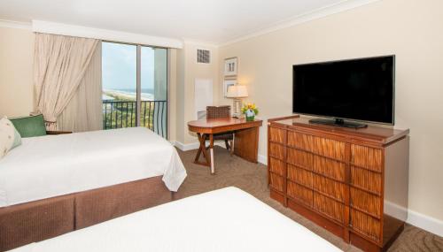a bedroom with a bed and a flat screen tv at One Ocean Resort and Spa in Atlantic Beach