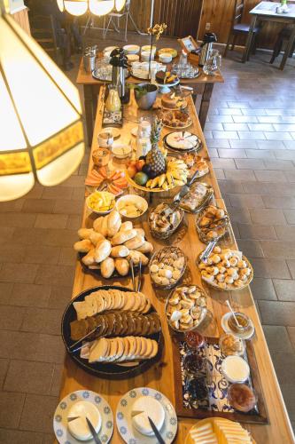 een lange tafel met veel borden eten erop bij Pousada Aguia da Montanha in Monte Verde