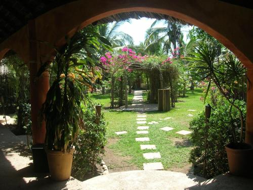 an archway leading to a garden with plants and flowers at Bambuddha Centro Holistico in Barra Vieja