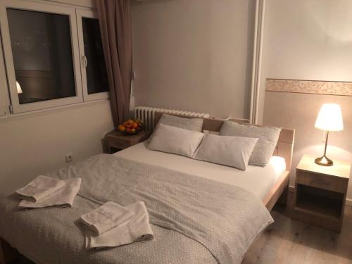 a bedroom with a bed with two towels on it at Apartmani Paku in Belgrade