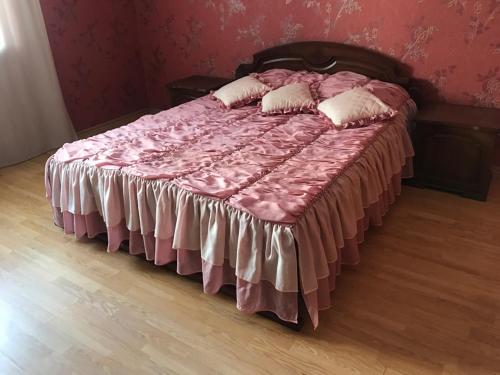 a bed with a pink blanket and pillows on it at Двухкомнатные апартаменты в центре города Карла Маркса 163 in Tambov