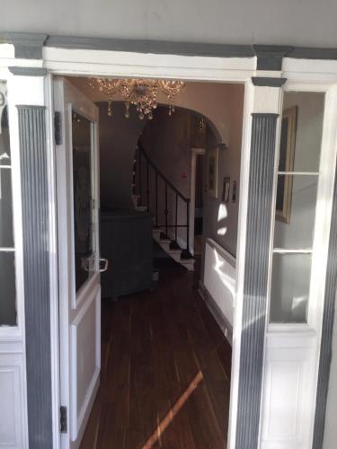 a hallway with an open door and a stairway at The Ocean Inn in Edinburgh
