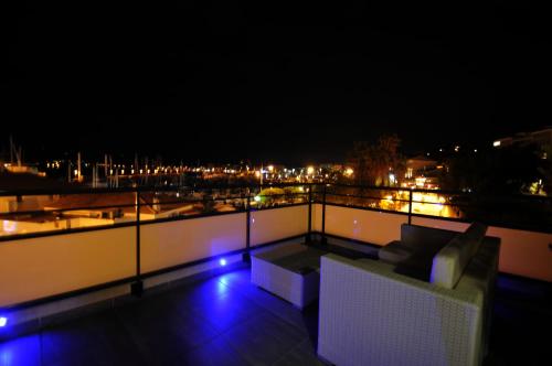 a balcony with a couch on the roof at night at Hôtel Baptistin in Le Lavandou